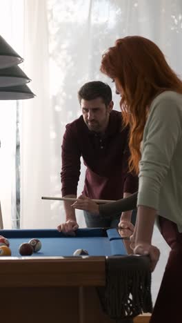 black woman hitting ball into pocket while playing pool game
