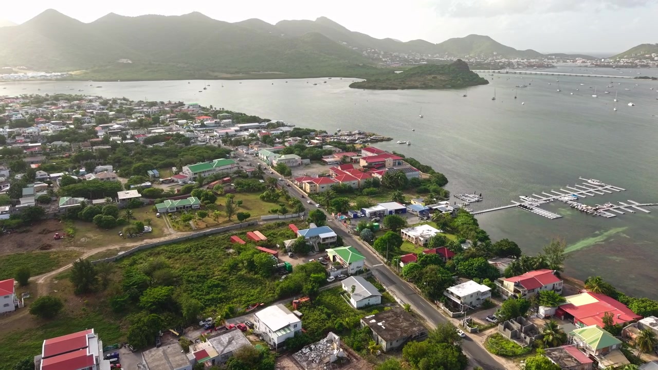 Ripresa con drone dell'isola di Saint Martin, edifici della città di Marigot e laguna di Simpson Bay in una sera di sole