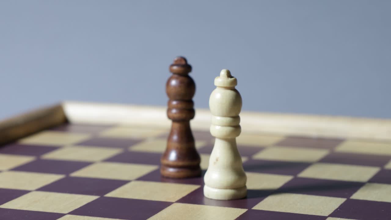 Cinematic rotating shot of black and white queen on a chessboard