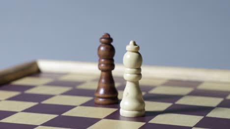 cinematic rotating shot of black and white queen on a chessboard