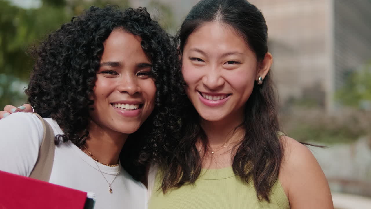 Close up of Asian and African-American female students with notebooks and books