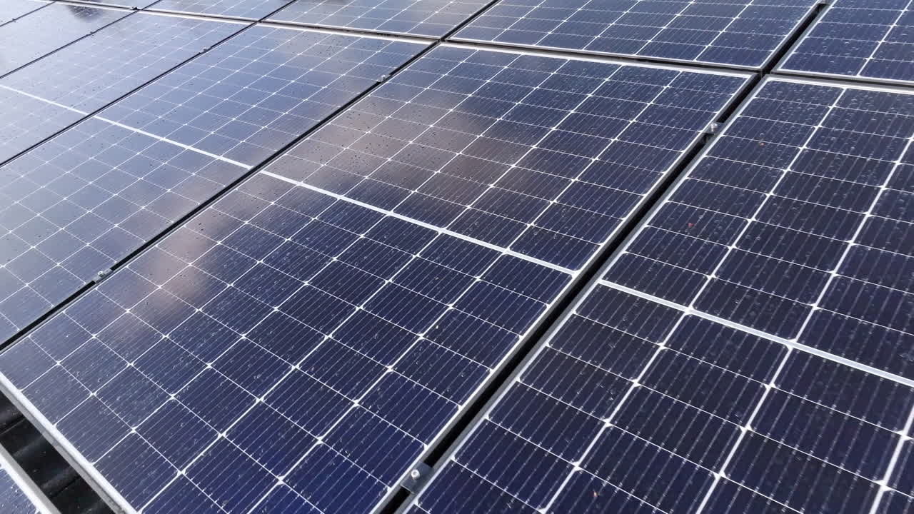 Vista aérea baixa sobre painéis solares sujos num telhado de casa, dia ensolarado