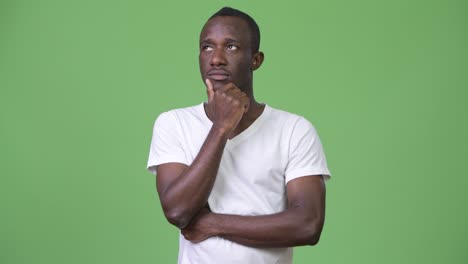 young african man thinking against green background