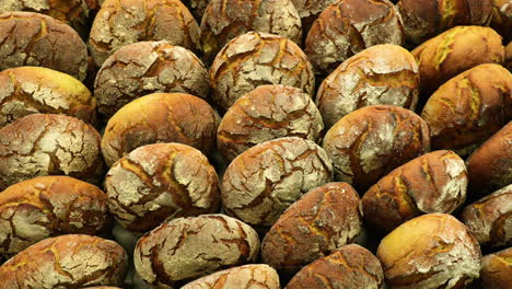 Trozos-De-Pan-De-Masa-Fermentada-En-Un-Estante,-Recién-Horneados-En-Una-Panadería,-Tiro-En-órbita-A-Cámara-Lenta,-Vista-Superior