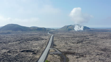 Vuelo-Con-Vista-De-Drones-Hacia-La-Carretera-De-Circunvalación,-La-Carretera-Más-Importante-De-Islandia,-Que-Muestra-Un-Panorama-Impresionante.-Vista-Aérea-Que-Revela-La-Planta-De-Energía-Geotérmica-Que-Produce-Energía-Verde-Alternativa