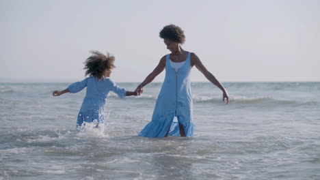 loving mother and her cute daughter playing together and having fun in the sea