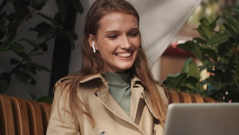 caucasian female video calling on laptop outdoors.