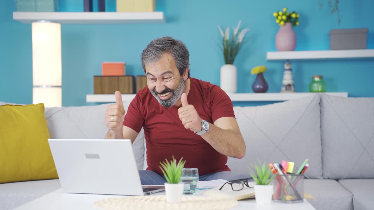 el hombre que está contento con lo que ve en la computadora portátil. se regocija.