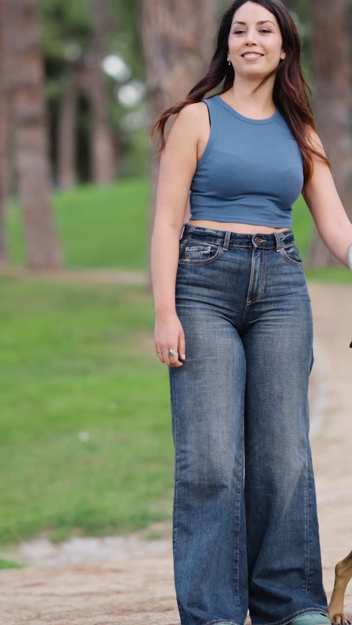 Two women walking a dog in a park