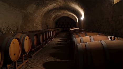 atmospheric wine cellar with rows of aging barrels