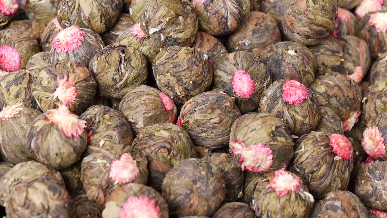 Hand picking flower tea balls in a market