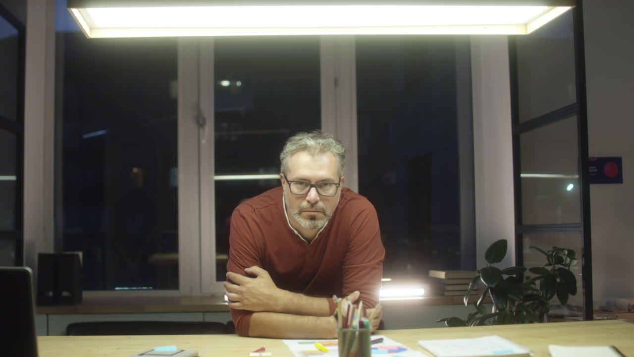 Ritratto di uomo d'affari di mezza età fino a tardi in ufficio
