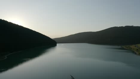 AERIAL---Sunrise-at-Frumoasa-Dam-in-Transylvania,-Romania,-wide-shot-truck-right