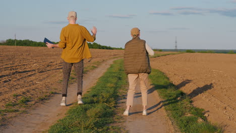 farmers walking on a dirt road in a field