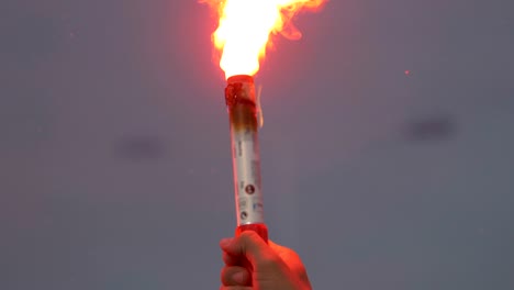 close-up of a burning signal flare held by a man in 4k slow motion 60fps