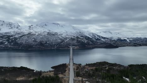 aerial view of a bridge with snowy fields and mountains in narvik, norway