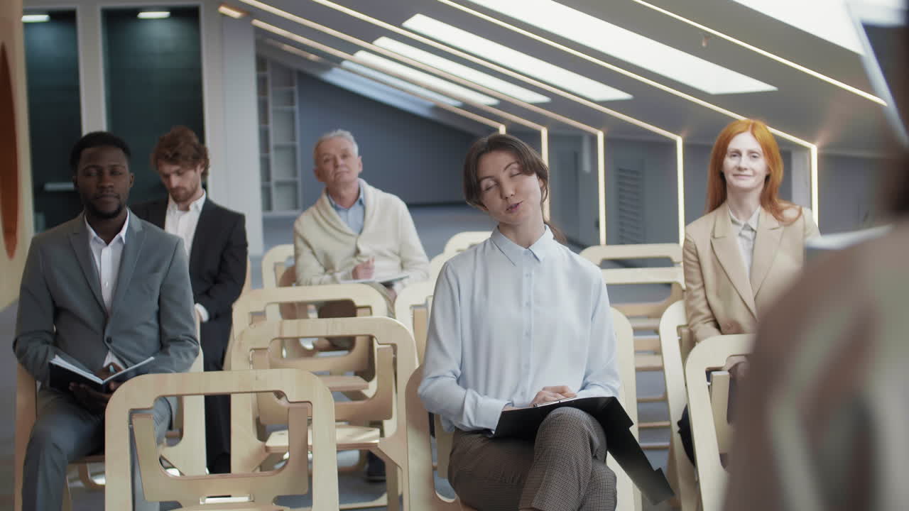 молодая женщина задает спикеру вопрос во время пресс-конференции