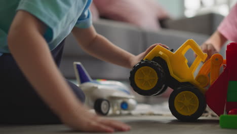 toddler tries to move wall built with small blocks by sister