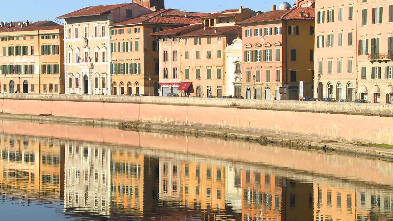 Edifici fiancheggiano e si riflettono in un canale simmetrico a Pisa, Italia 3