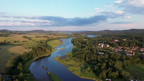 a cinematic view from the drone as it flies over the river and captures its wide surroundings from a height