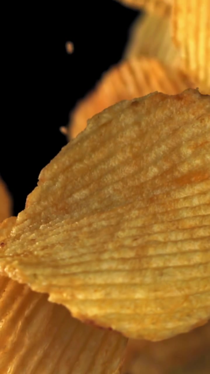 Crispy Golden Crinkle Cut Potato Chips Falling in Slow Motion