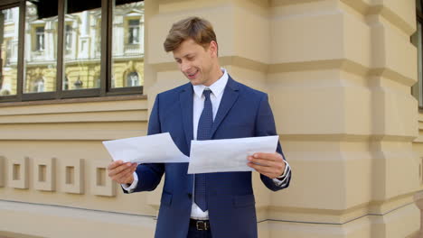 hombre de negocios exitoso leyendo documentos al aire libre