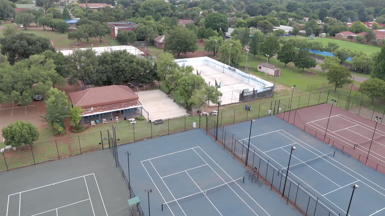 옛 테니스 클럽의 테니스 코트에서 찍은 천천히 오른쪽으로 기울어지는 공중 촬영으로 도시의 나머지 부분을 드러니다.