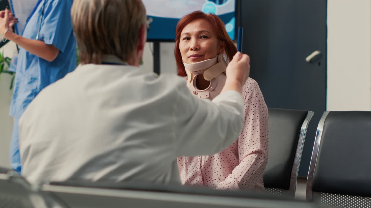 Doctor Consulting with Patient Wearing Cervical Collar