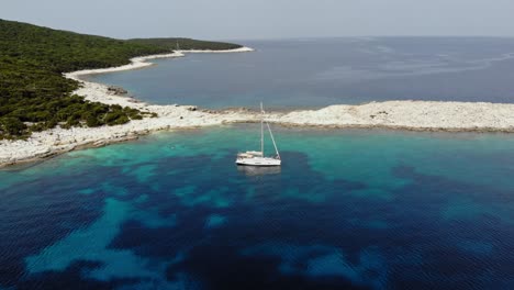 Weißes-Boot-Verankert-In-Der-Nähe-Des-Kiesstrandes-Von-Emplisi-Auf-Der-Insel-Kefalonia---Luftaufnahme