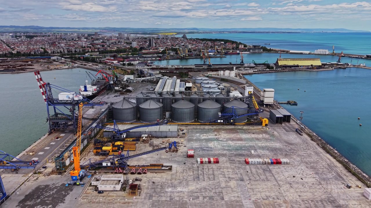 Frachtumschlag findet im Hafen mit Silos und Schiffen statt