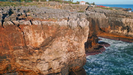 cinematic panorama coastal rocks over ocean waves. aerial rough volcanic cliffs