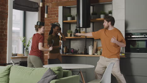 three  roomates having fun fighting with kitchen utensils at home