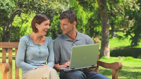 una joven pareja navegando en su computadora portátil