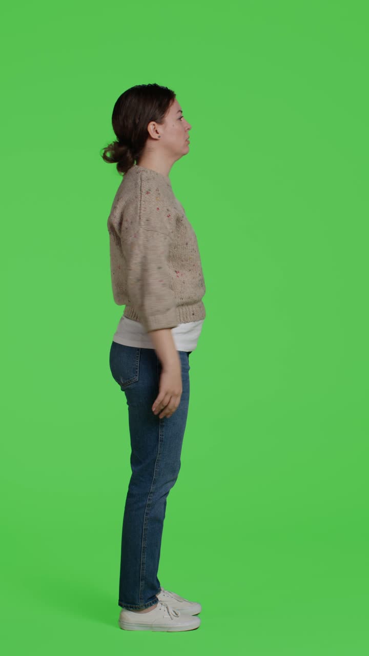 Vertical video: Profile of upset frustrated woman acting angry on full body greenscreen