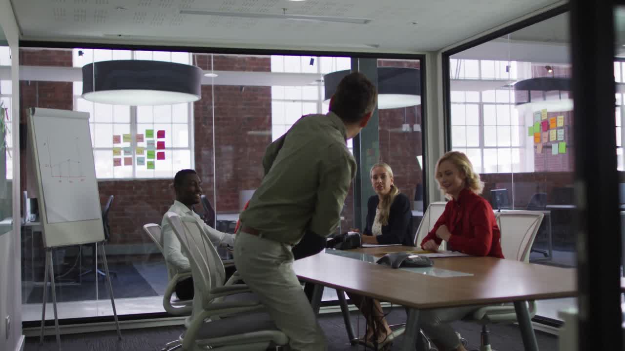 hombre de negocios asiático llegando tarde a una reunión con un grupo diverso de colegas de negocios en la sala de reuniones