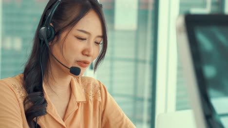 Businesswoman-wearing-headset-working-actively-in-office