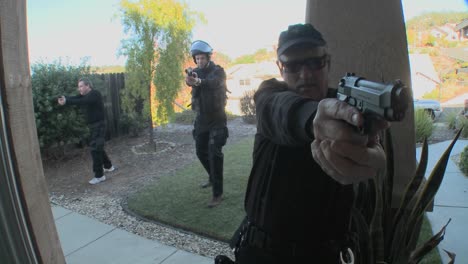 oficiales de la dea o swat con los brazos en alto golpean la puerta antes de realizar un allanamiento de drogas en una casa 1
