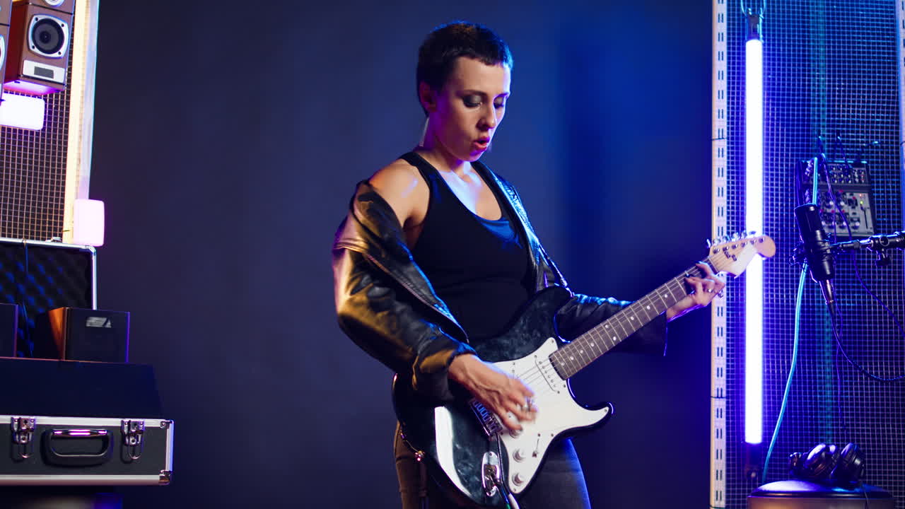 Woman Playing Electric Guitar in Studio
