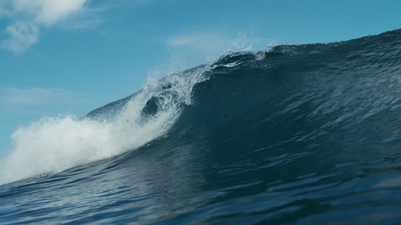 Tight barrel wave forms offshore with vibrant turquoise color and clean smooth textured softness