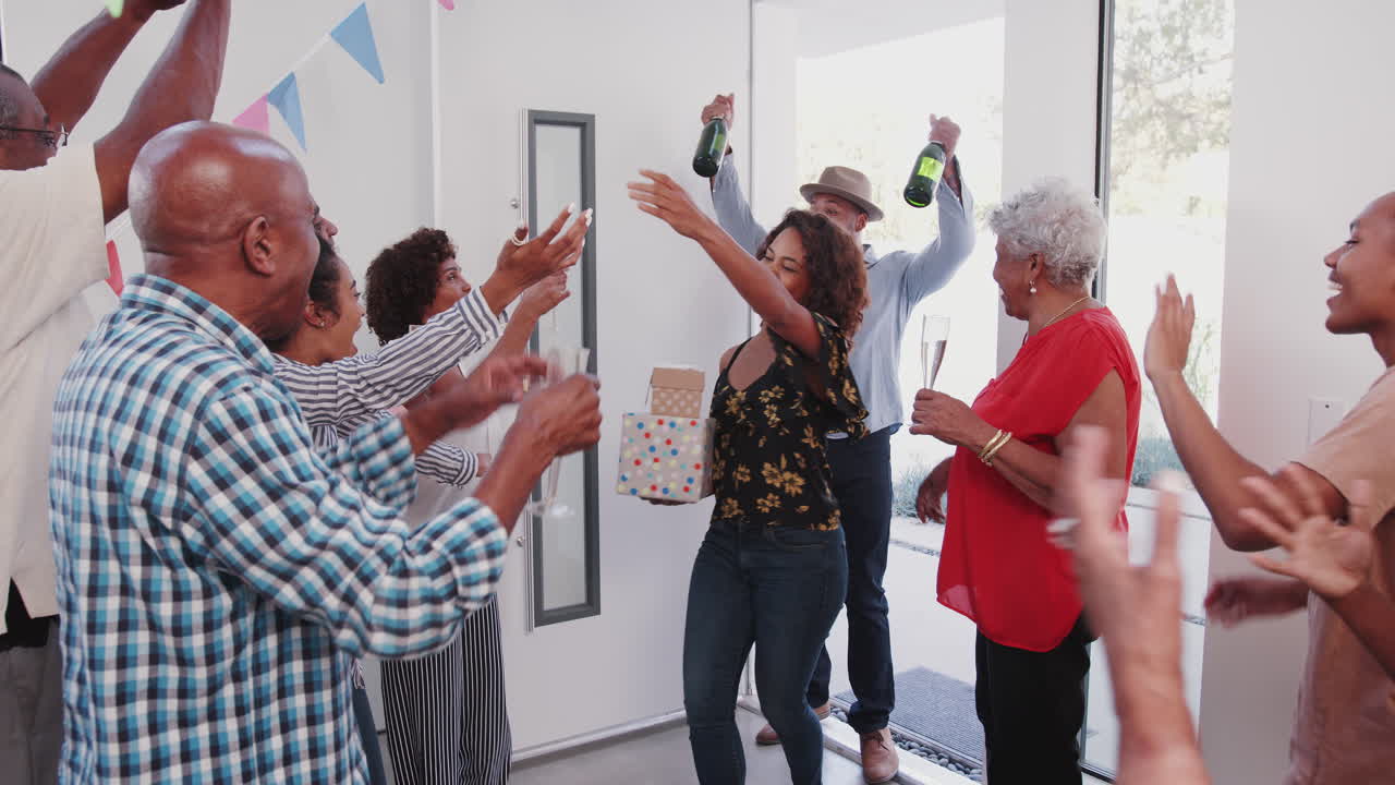 Relatives are welcomed as they are arrive at a multi-generation black family birthday party