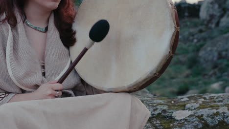 Spirituelle-Frau,-Die-Friedlich-Eine-Schamanische-Trommel-In-Einem-Wunderschönen-Mittelalterlichen-Dorf-Spielt,-Statische-Detailaufnahme