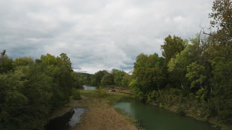 River-Between-Green-Lush-Forest-In-Durham,-Arkansas,-USA---Aerial-Pullback