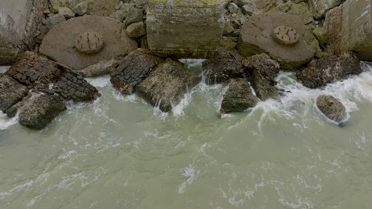 카로스타 북부 요새, 발트해 연안, 큰 파도, 흐린 날, 느린 동작, 뒤로 움직이는 드론 샷에 있는 버려진 해변 요새 건물의 공중 설정