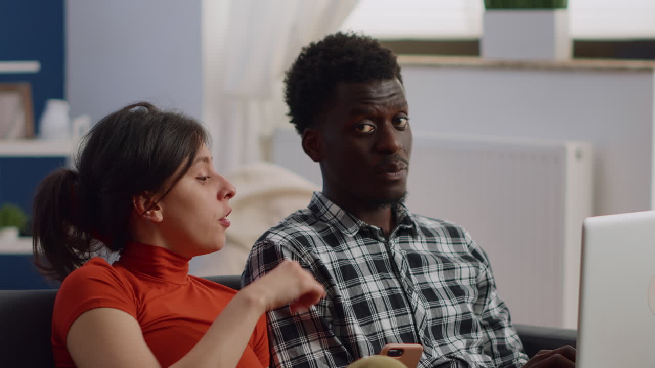 Close up of interracial couple having modern devices