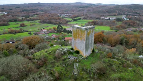 Sandiás-tower-of-ourense,-spain,-aerial-orbit-around-hillside-and-farmland