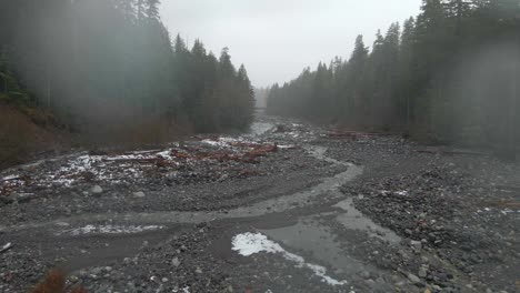 Fly-over-a-river-in-Mount-Rainer-National-Park-in-Washington-on-a-rainy-cloudy-day