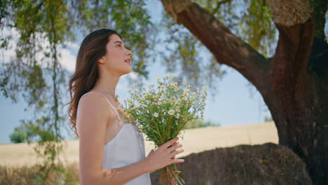 gentle model sniffing bloom at summer portrait. carefree woman enjoying freedom