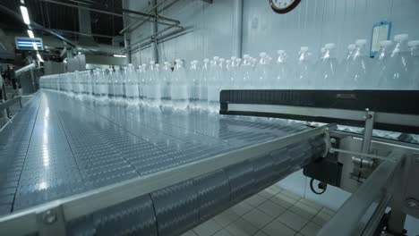 cinta transportadora con botellas de agua potable en una planta de bebidas moderna