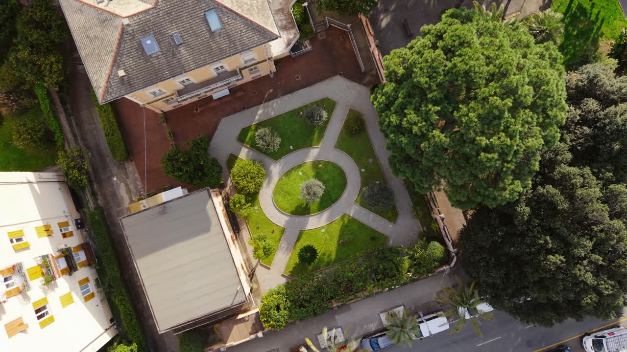 Geometric garden with paths and trees in a quiet Italian neighborhood, aerial view