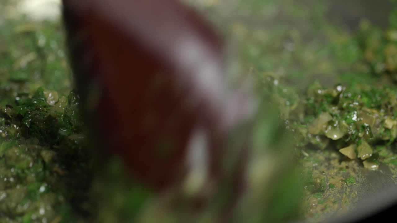 agitando los ingredientes para una salsa de café de parís en una sartén caliente